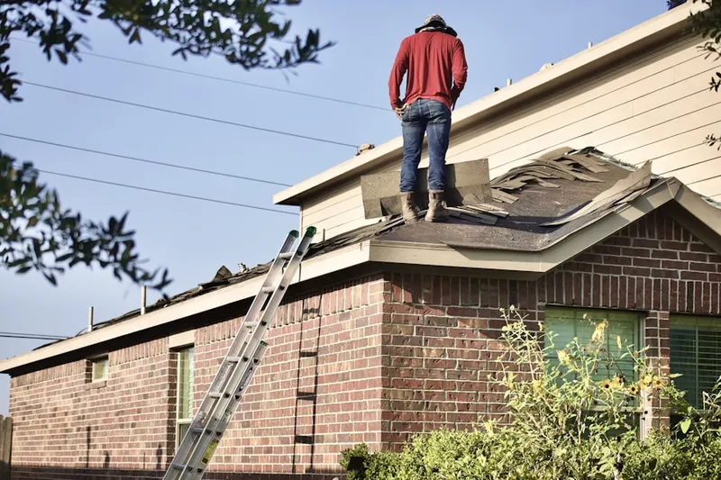 Professional roofer working on a residential roof in Doffing